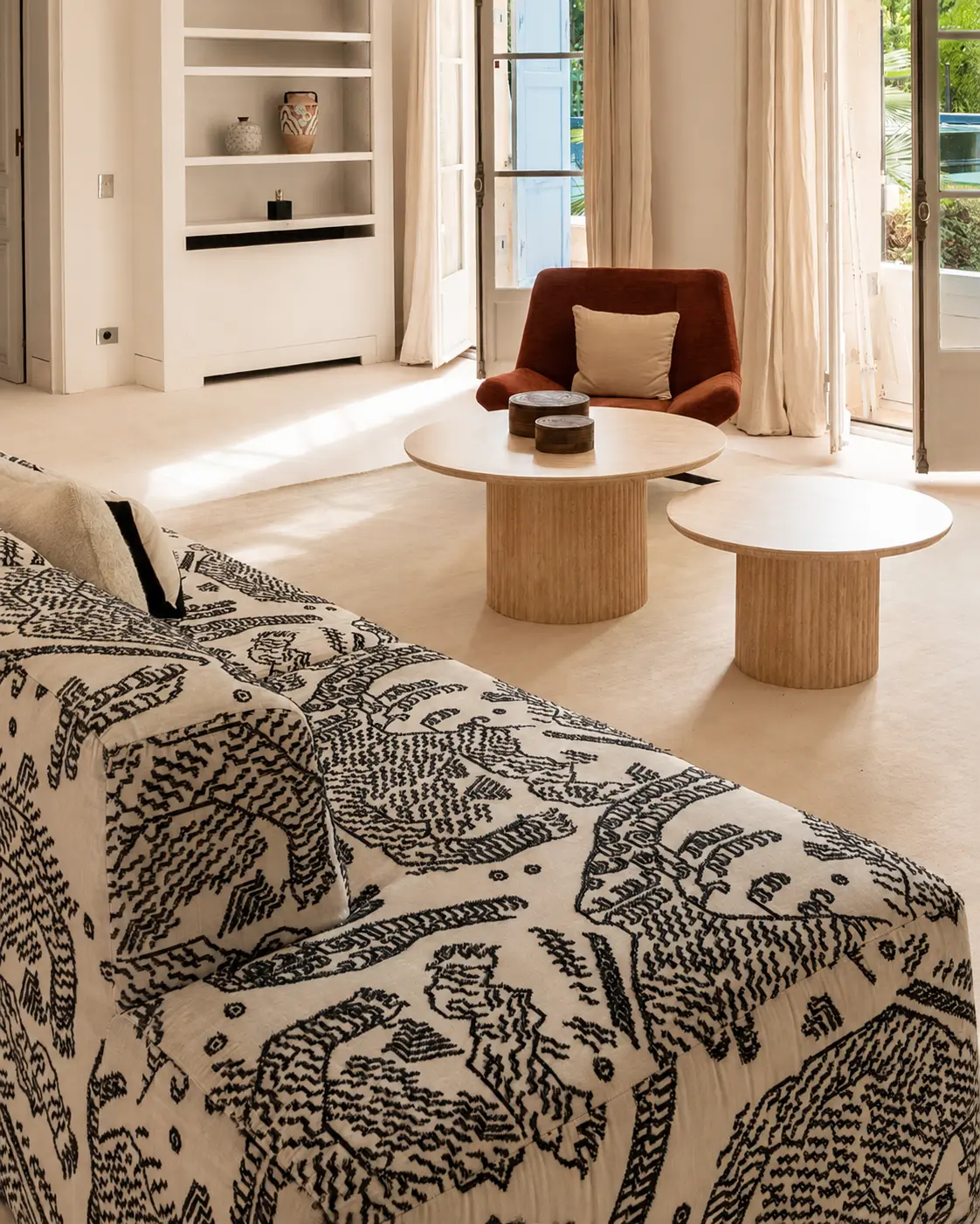 Sitting room with a patterned sofa, opening onto the garden