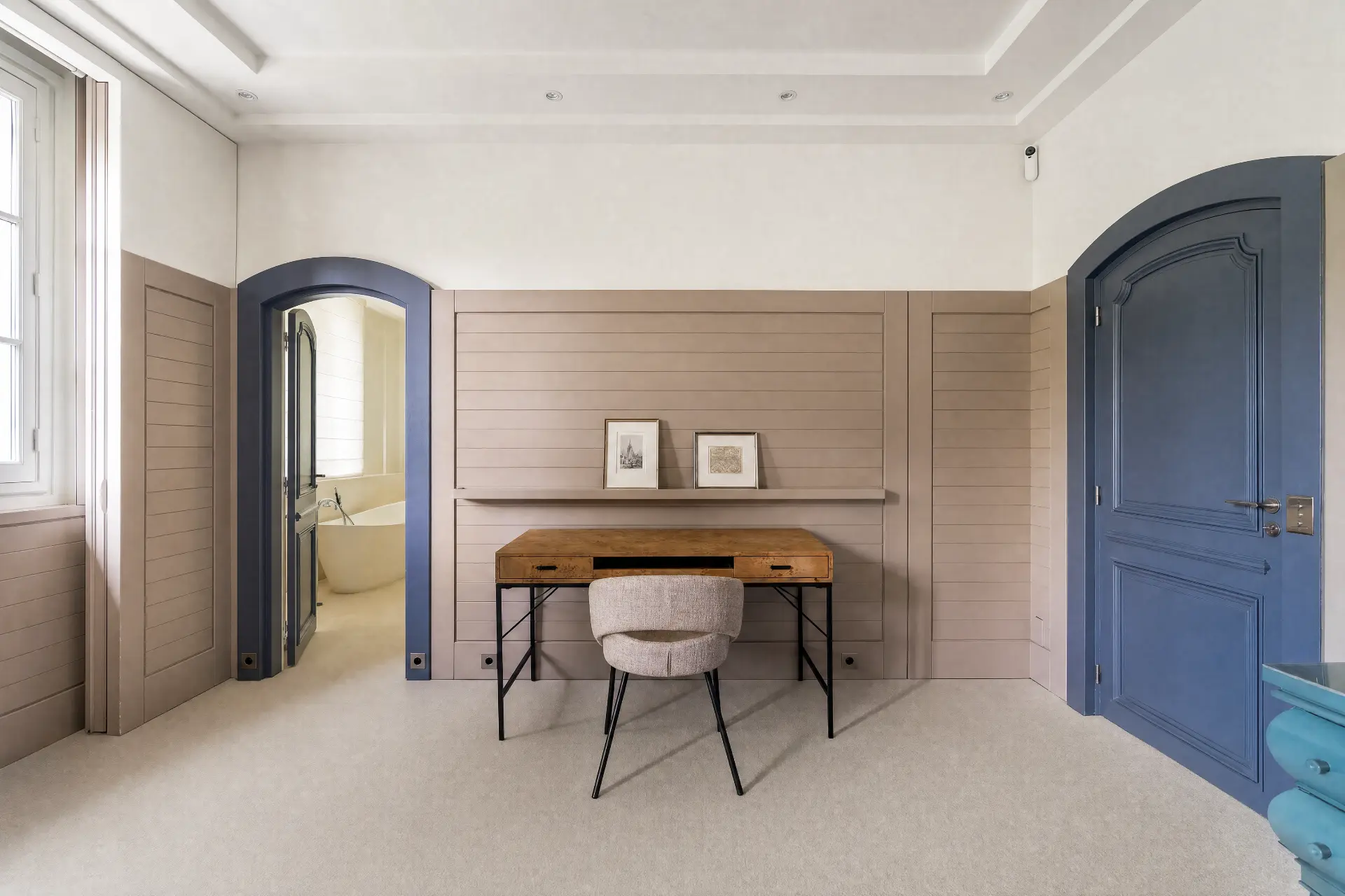 A writing desk between arched blue doors